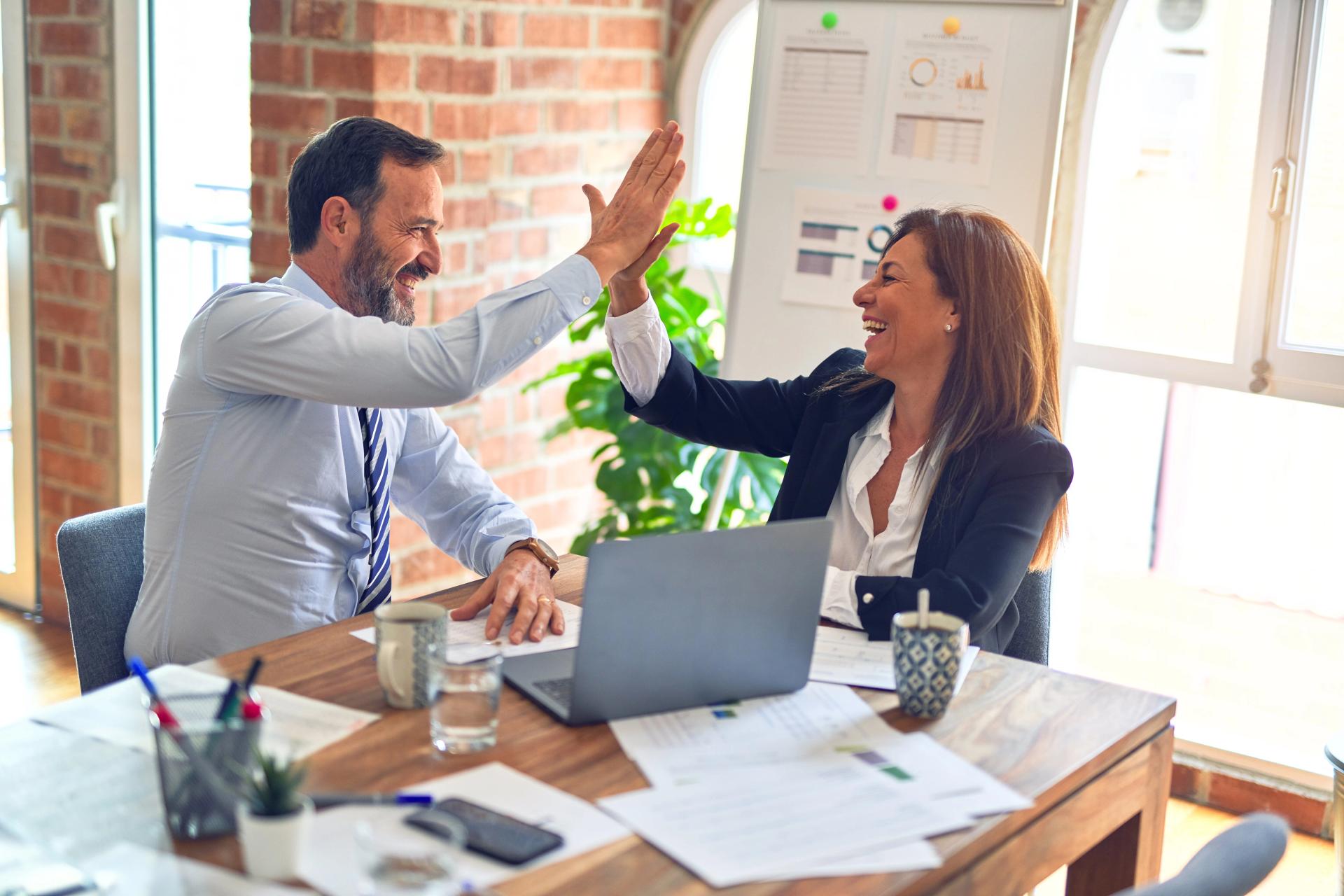 Two happy business people high fiving